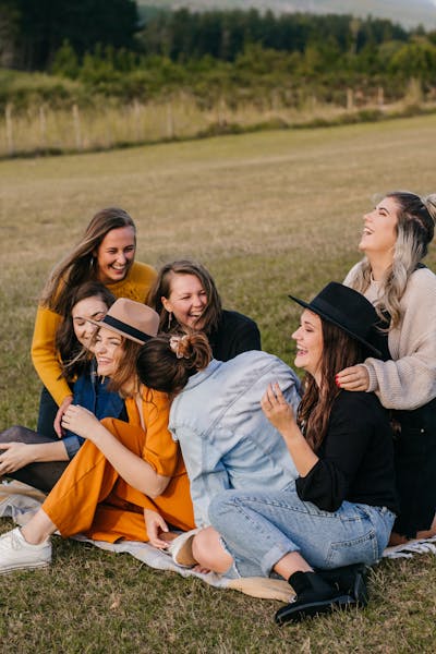 Friends laughing together outdoors, happy uplifting cannabis strain effect for social settings